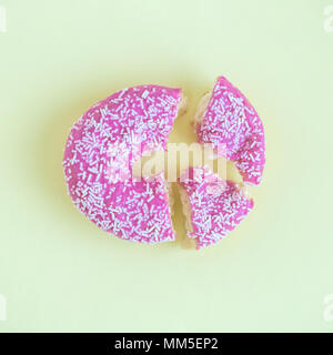 Broken donut on pastel yellow background minimal creative concept. Stock Photo
