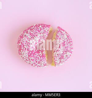 Broken donut on pastel pink background minimal creative concept. Stock Photo