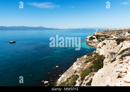 a view of the coast of Sant Elia in Cagliari, Sardinia, highlighting the Prezzemolo tower on the right and the port of Cagliari in the background Stock Photo