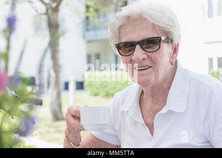 Portrait of senior woman having coffee in nursing home Stock Photo