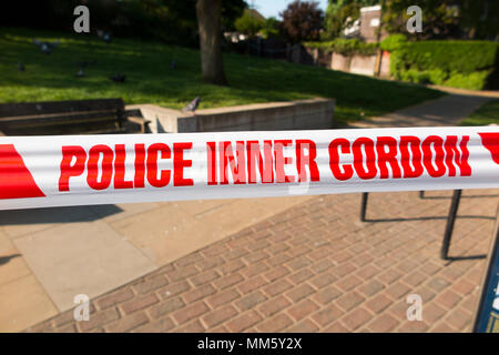 Inner cordon tape barrier placed by police or scene of crime officer / officers at the site of a stabbing where someone was stabbed with a knife. UK Stock Photo