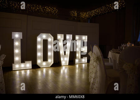 Illuminated Love sign in large letters at a wedding reception Stock Photo