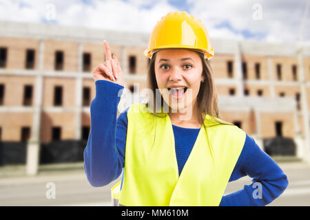 Young female engineer or architect having great idea as smart building solution concept on outdoor construction site background Stock Photo