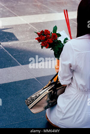 Woman pilgrim with offerings at the Trimurti statue God of Love at Central World in Bangkok in Thailand in Southeast Asia Far East. Reportage Travel Stock Photo