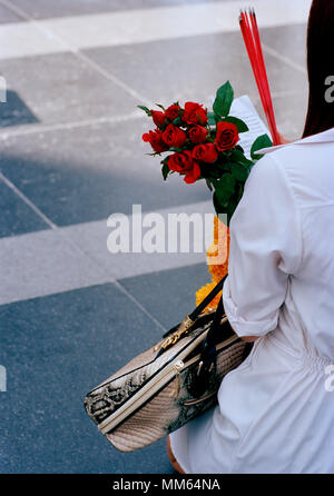 Woman pilgrim with offerings at the Trimurti statue God of Love at Central World in Bangkok in Thailand in Southeast Asia Far East. Reportage Travel Stock Photo