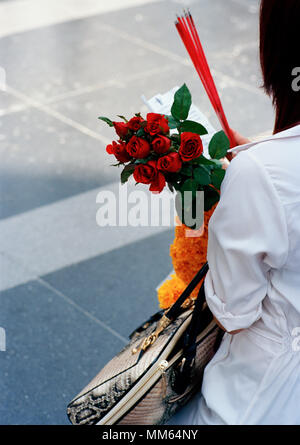 Woman pilgrim with offerings at the Trimurti statue God of Love at Central World in Bangkok in Thailand in Southeast Asia Far East. Reportage Travel Stock Photo