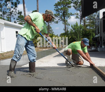 Workers spreading out and leveling freshly poured concrete, USA 2018, © Katharine Andriotis Stock Photo