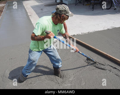Worker spreading out freshly poured concrete, USA 2018, © Katharine Andriotis Stock Photo
