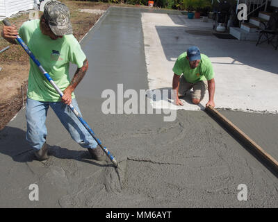 Workers spreading out and leveling freshly poured concrete, USA 2018, © Katharine Andriotis Stock Photo