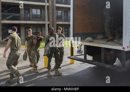 U.S. Marines with Marine Corps Air Station (MCAS),  remove the sandbags from in front of first deck barracks room doors into a loading truck aboard MCAS, Beaufort, S.C., Sept., 11.  Sandbags were placed to minimize damage in preparation of impacts caused by Hurricane Irma. (U.S. Marine Corps photo by Lance Cpl. Cameron D. Darrough/ Released) Stock Photo