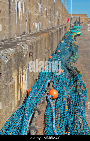 MACDUFF ABERDEENSHIRE SCOTLAND LONG LINES OF FISHING NETS DRYING AGAINST THE HARBOUR WALL Stock Photo