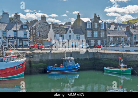 MACDUFF ABERDEENSHIRE SCOTLAND SHIPYARD OR BOATYARD BOATS IN THE HARBOUR ALONGSIDE THE MAIN ROAD AND SHOPS PART TWO Stock Photo