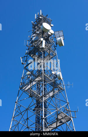 Telecommunication tower with antennas against the blue sky. View from below Stock Photo