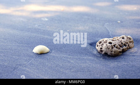 PULAU LANGKAWI, MALAYSIA - APR 7th 2015: Famous black sand beach with closeup of stone. Stock Photo