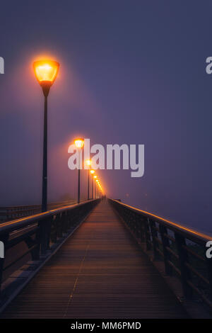 person walking on dark street illuminated with streetlamps Stock Photo ...