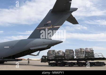 Palletized cargo is moved in to position behind the tail of C-17A Globemaster III of the 445th Airlift Wing, Wright-Patterson Air Force Base, Ohio, Air Force Reserve Command, as members of the 35th Combat Communciations Squadron and their equipment deploy from Tinker Air Force Base, Oklahoma, to Florida as part of the Air Force's Hurricane Irma response and recovery operations to provide humanitarian relief Sept. 13, 2017. The eight Citizen Airmen from the 35th CBCS deployed servers, radio equipment, power generation and other tools to connect to Department of Defense networks, voice communica Stock Photo