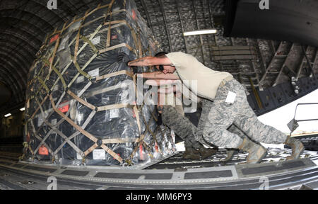 Airmen from the 72nd Logistics Readiness Squadron, aerial port section, push palletized cargo is to the tail of C-17A Globemaster III of the 445th Airlift Wing, Wright-Patterson Air Force Base, Ohio, Air Force Reserve Command, as members of the 35th Combat Communciations Squadron and their equipment deploy from Tinker Air Force Base, Oklahoma, to Florida as part of the Air Force's Hurricane Irma response and recovery operations to provide humanitarian relief Sept. 13, 2017. The eight Citizen Airmen from the 35th CBCS deployed servers, radio equipment, power generation and other tools to connec Stock Photo