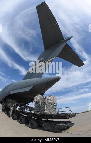 Palletized cargo is moved in to position behind the tail of C-17A Globemaster III of the 445th Airlift Wing, Wright-Patterson Air Force Base, Ohio, Air Force Reserve Command, as members of the 35th Combat Communciations Squadron and their equipment deploy from Tinker Air Force Base, Oklahoma, to Florida as part of the Air Force's Hurricane Irma response and recovery operations to provide humanitarian relief Sept. 13, 2017. The eight Citizen Airmen from the 35th CBCS deployed servers, radio equipment, power generation and other tools to connect to Department of Defense networks, voice communica Stock Photo