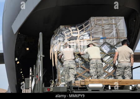 Airmen from the 72nd Logistics Readiness Squadron, aerial port section, push palletized cargo is to the tail of C-17A Globemaster III of the 445th Airlift Wing, Wright-Patterson Air Force Base, Ohio, Air Force Reserve Command, as members of the 35th Combat Communciations Squadron and their equipment deploy from Tinker Air Force Base, Oklahoma, to Florida as part of the Air Force's Hurricane Irma response and recovery operations to provide humanitarian relief Sept. 13, 2017. The eight Citizen Airmen from the 35th CBCS deployed servers, radio equipment, power generation and other tools to connec Stock Photo