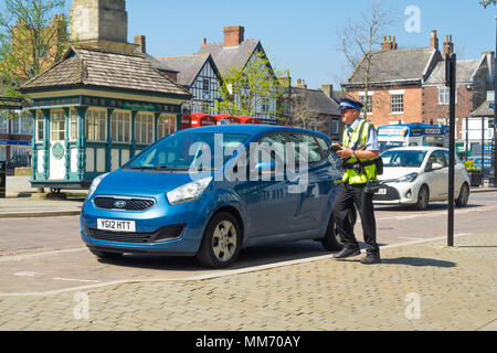 Traffic Warden taking details of a car improperly parked in Ripon Market Place North Yorkshire Stock Photo