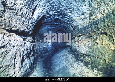 The old sandstone water tunnel, mined caves.  The cave. Sandstone tunnel moistened walls. Dry channel carved in the rocky underground Stock Photo