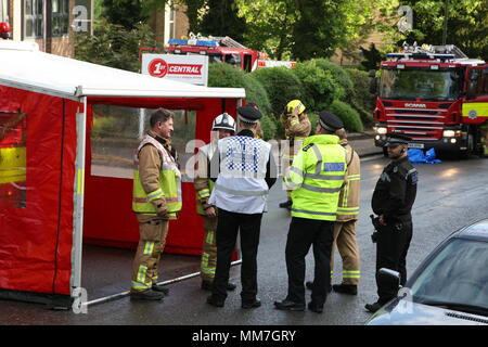 Haywards Heath, Sussex, UK. 10th May 2018. Emergency services discuss plans at the scene of the blaze. Several units from the fire service and police close off Perrymount Road in Haywards Heath, responding to a fire in a large office block. Credit: Roland Ravenhill/Alamy Live News