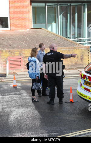 Haywards Heath, Sussex, UK. 10th May 2018. Workers arrive for work and are redirected by the police. Several units from the fire service and police close off Perrymount Road in Haywards Heath, responding to a fire in a large office block. Credit: Roland Ravenhill/Alamy Live News Stock Photo