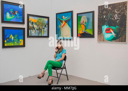 Hampstead, London, UK. 9th May, 2018. Angie with works on her Hanoi Art House stand - The Affordable Art Fair opens in Hampstead and runs until 14 May. The fair offers visitors a chance to purchase work from over 110 galleries at prices between £100 and £6,000 Credit: Guy Bell/Alamy Live News