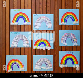 Children's art works on the wall in their school - rainbows Stock Photo