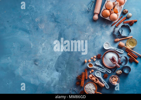 Baking utensils header. Measuring spoons, sea salt, eggs, flour, oil and sugar with whisks and cookie cutters on a modern concrete background with cop Stock Photo