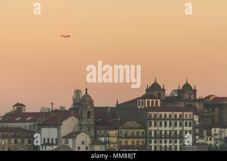 Close-up view of historic city of Porto, Portugal with plane flying over during sunrise time Stock Photo
