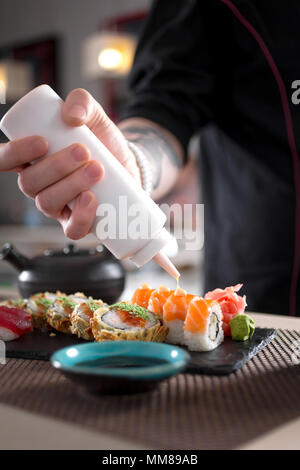Preparing sushi rolls in Jaopanese restaurant. Stock Photo