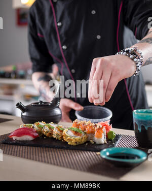 Preparing sushi rolls in Jaopanese restaurant. Stock Photo