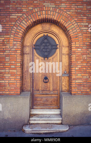 Old wooden door in brick wall Stock Photo
