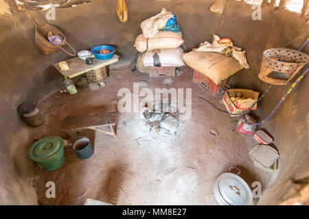 Interior of single-roomed hut with burnt out campfire in the middle, Mukuni Village, Zambia Stock Photo