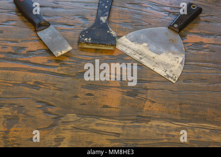spackle knife and paint scraper on wooden table Stock Photo