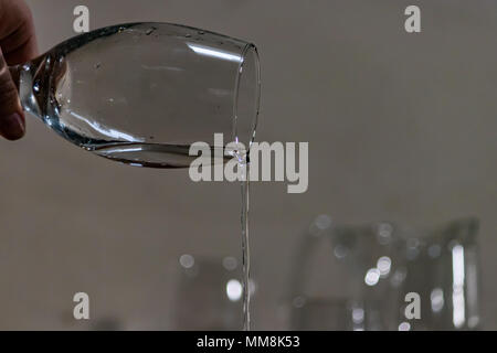 trickle of water poured out of glass Stock Photo