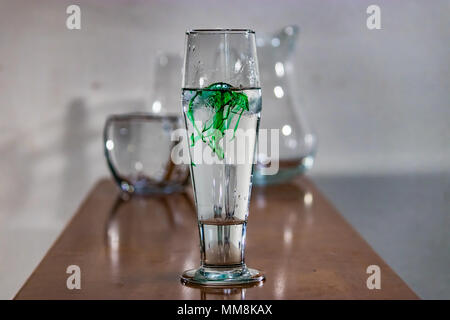 green food coloring in water on table Stock Photo