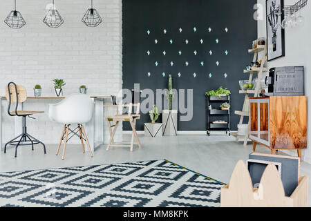 White room with decorative chalkboard wall, table and pattern carpet Stock Photo