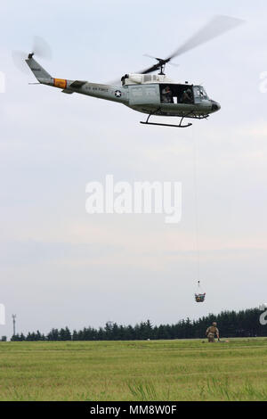 Staff Sgt. Justin Bender, 374th Operations Support Group survival, evasion, resistance and escape specialist, waits for a personnel basket to place a manikin into during a hoist training scenario at the 2017 Japanese-American Friendship Festival at Yokota Air Base, Japan, Sept. 16, 2017. The festival was an opportunity for Yokota to showcase some of its aerial capabilities while allowing visitors to enjoy live entertainment and view static displays. (U.S. Air Force photo by Staff Sgt. David Owsianka) Stock Photo