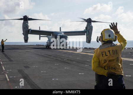 170917-N-DC385-461 PHILIPPINE SEA (Sept. 17, 2017) Aviation Boatswain’s Mate (Handling) 3rd Class Tiffanie Allender, from Joplin, Mo., signals to the pilot of an MV-22B Osprey, assigned to the “Dragons” of Marine Medium Tiltrotor Squadron (VMM) 265 (Reinforced), on the flight deck of the amphibious assault ship USS Bonhomme Richard (LHD 6) during the squadron’s disembarkation from the ship. The disembarkation signals the end of the squadron’s final deployment with BHR as the ship is scheduled to turn over duties with the amphibious assault ship USS Wasp (LHD 1) in winter 2018. Bonhomme Richard Stock Photo