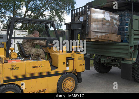 Soldiers from Alpha Battery, 1st Battalion, 265th Air Defense Artillery Regiment, load pallets of meals ready-to-eat, that will be distributed to citizens of Florida throughout the state at various shelters and points of distribution, following Hurricane Irma, Sept. 14, 2017. Hurricane Irma passed through Florida leaving a trail of destruction with heaviest damage in South Florida. The Florida National Guard and various units from other states, activated their troops to collectivly help with relief efforts. Stock Photo