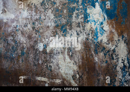 A textured pattern of white paint and brown rust on a blue metal surface Stock Photo