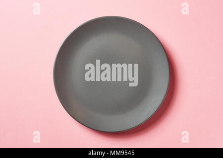 Round grey plate on pink background, top view Stock Photo
