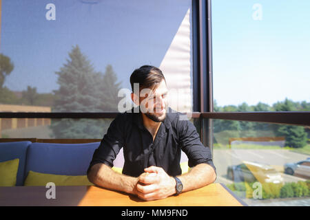 Young businessman sitting at office on sofa and wearing black shirt. Stock Photo