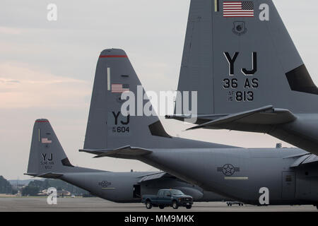 Three C-130J Super Hercules’ sit on the flightline at Yokota Air Base, Japan, Sept. 20, 2017. The C-130J shown in the middle is the fifth to be delivered to Yokoa and the first from Ramstein Air Base, Germany. Crewmembers from the 36th Airlift Squadron flew halfway around the world to deliver this aircraft here. Yokota serves as the primary Western Pacific airlift hub for U.S. Air Force peacetime and contingency operations. Missions included tactical airland, airdrop, aeromedical evacuation, special operations and distinguished visitor airlift. (U.S. Air Force photo by Yasuo Osakabe) Stock Photo