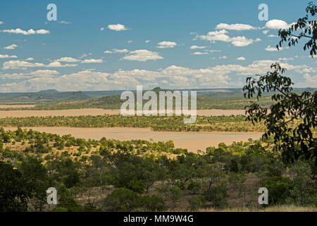 Spectacular landscape with wooded islands rising from waters of immense lake formed by Burdekin Falls dam & hemmed by trees under blue sky, Australia Stock Photo