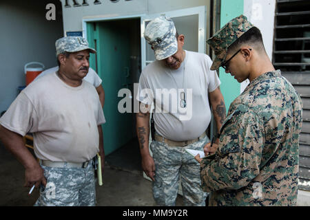 U.S. Marine Corps Cpl. Fransisco J. Rodriguez, right, the “Spartan Corporal” for Battalion Landing Team 2nd Battalion, 6th Marine Regiment, 26th Marine Expeditionary Unit (MEU), collects information from U.S. Army Staff Sgt. Rene Rodriguez, center, a local recruiter, to assist in relief efforts for victims of Hurricane Maria in Ceiba, Puerto Rico, Sept. 24, 2017. The 26th MEU is supporting the Federal Emergency Management Agency, the lead federal agency, and local authorities in Puerto Rico and the U.S. Virgin Islands with the combined goal of protecting the lives and safety of those in affect Stock Photo