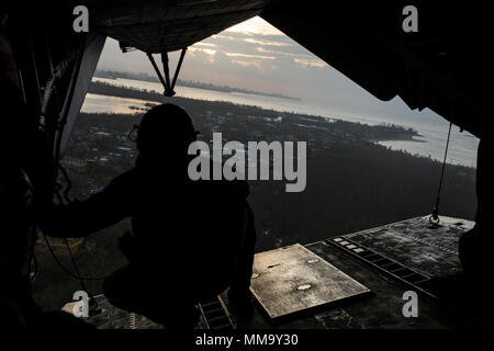 170924-N-AY374-148 SAN JUAN, Puerto Rico (Sept. 24, 2017) Lance Cpl. Matthew Johnson, assigned to the 26th Marine Expeditionary Unit, looks out of the back of a CH-53E Superstallion as it flies over Puerto Rico. Kearsarge and the 26th MEU are assisting with relief efforts in the aftermath of Hurricane Maria. The Department of Defense is supporting the Federal Emergency Management Agency, the lead federal agency, in helping those affected by Hurricane Maria to minimize suffering and is one component of the overall whole-of-government response effort. (U.S. Navy Photo by Mass Communication Speci Stock Photo