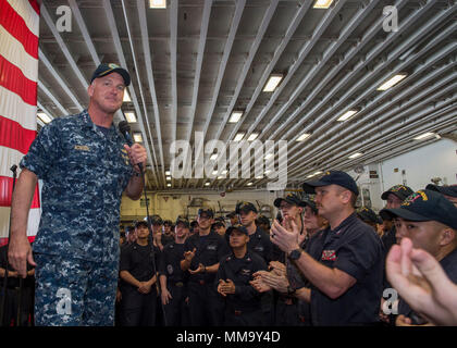 170925-N-DC385-501 SASEBO, Japan (Sept. 25, 2017) Vice Adm. Tom Rowden, commander, Naval Surface Forces, addresses Sailors during an all-hands call in the ship’s hangar bay of the amphibious assault ship USS Bonhomme Richard (LHD 6). Rowden is visiting Fleet Activities Sasebo, home of the 7th Fleet’s forward-deployed amphibious ships, to better understand forward-deployed readiness challenges and to discuss the role of the new command Naval Surface Group Western Pacific organization. (U.S. Navy photo by Mass Communication Specialist Seaman Cosmo Walrath/Released) Stock Photo